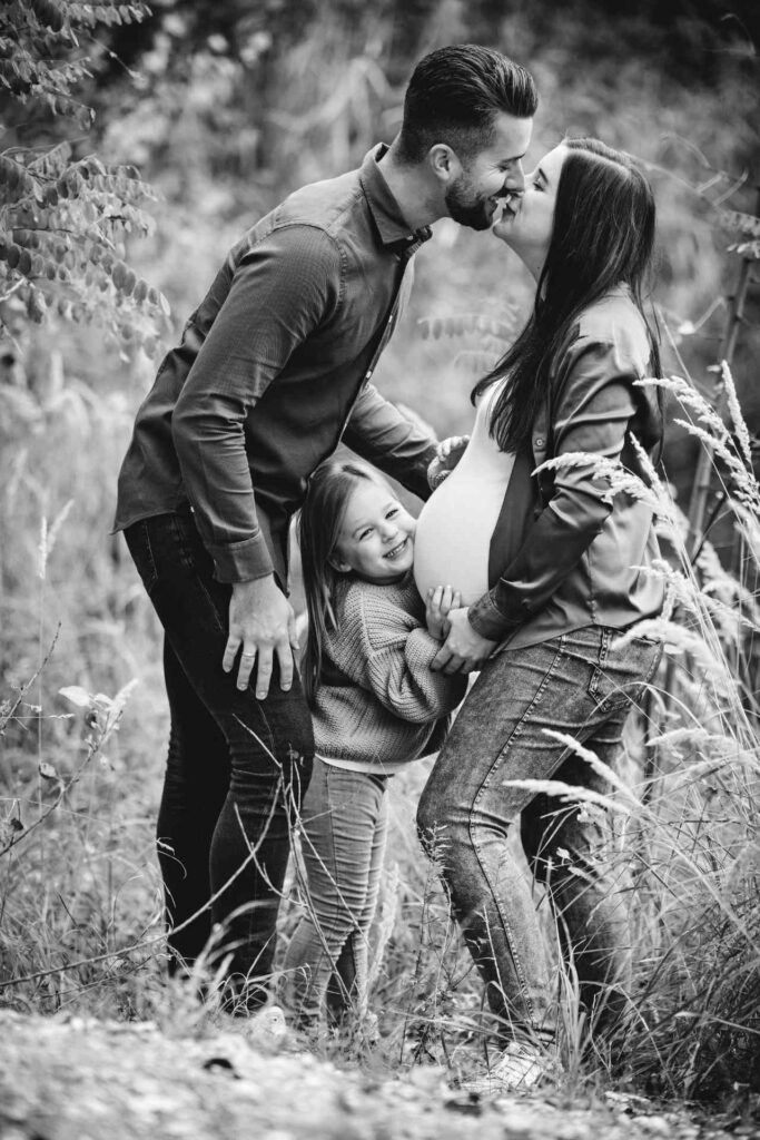 Schwangere Frau mit Partner und Kind im Wald, Babybauch Fotoshooting outdoor in Schwarzweiß