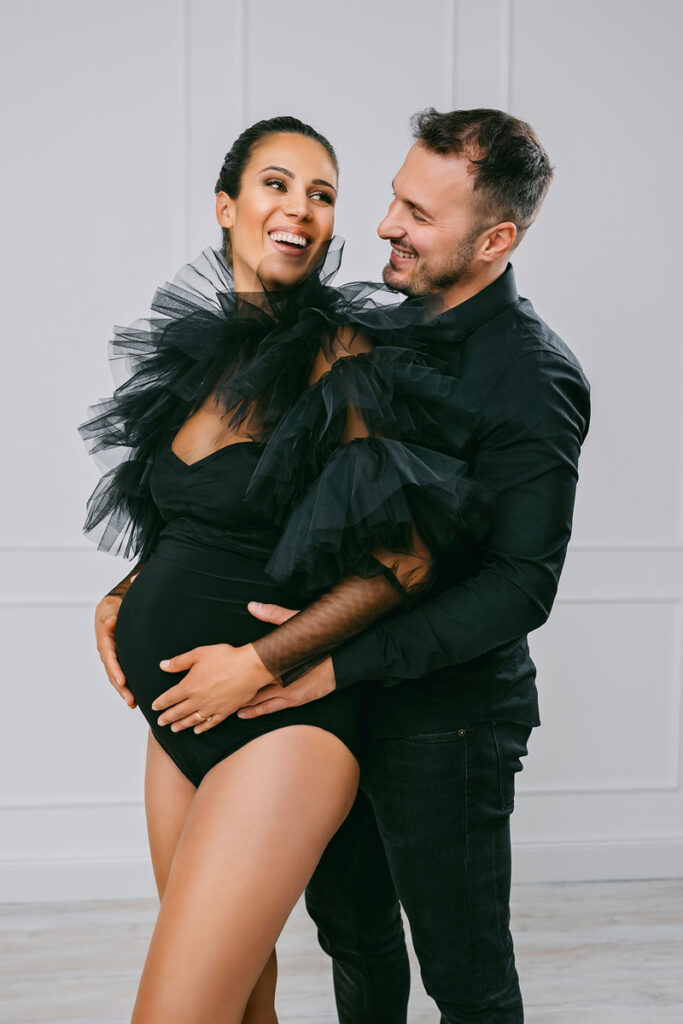 Werdende Eltern in Schwarz beim gemeinsamen Babybauch Fotoshooting