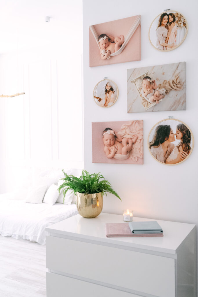 Gerahmte Babyfotos als Wandbilder über einer weißen Kommode