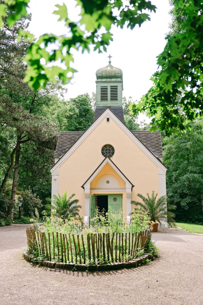 Taufe in der Pilgerkirche Heilige Rosalia – Taufpatin mit Taufkerze am Taufbecken